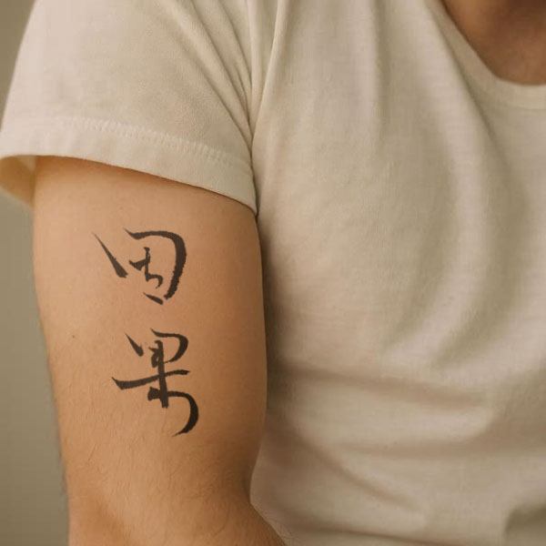 Chinese tattoo placement example of Karma (因果 yinguo) on upper arm